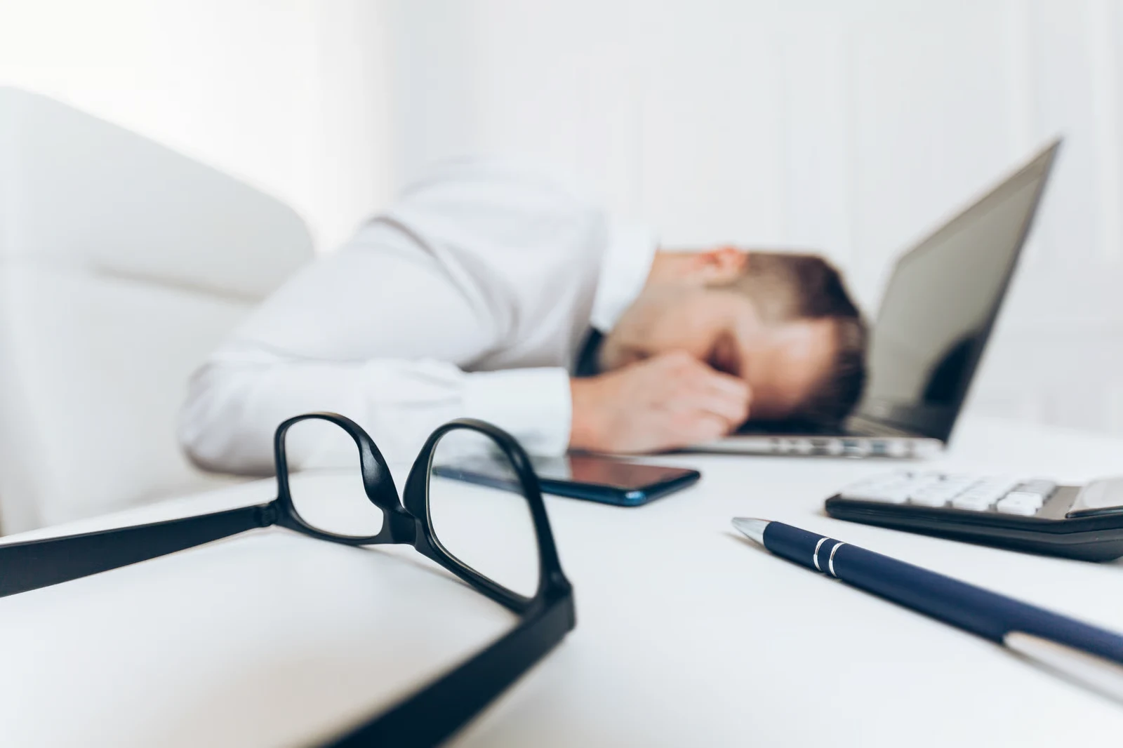 Dirigeant épuisé, tête posée sur le bureau — la charge allostatique et le coût caché de l adaptation.